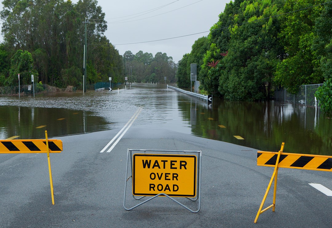 flood water on road with warning signs for traffic